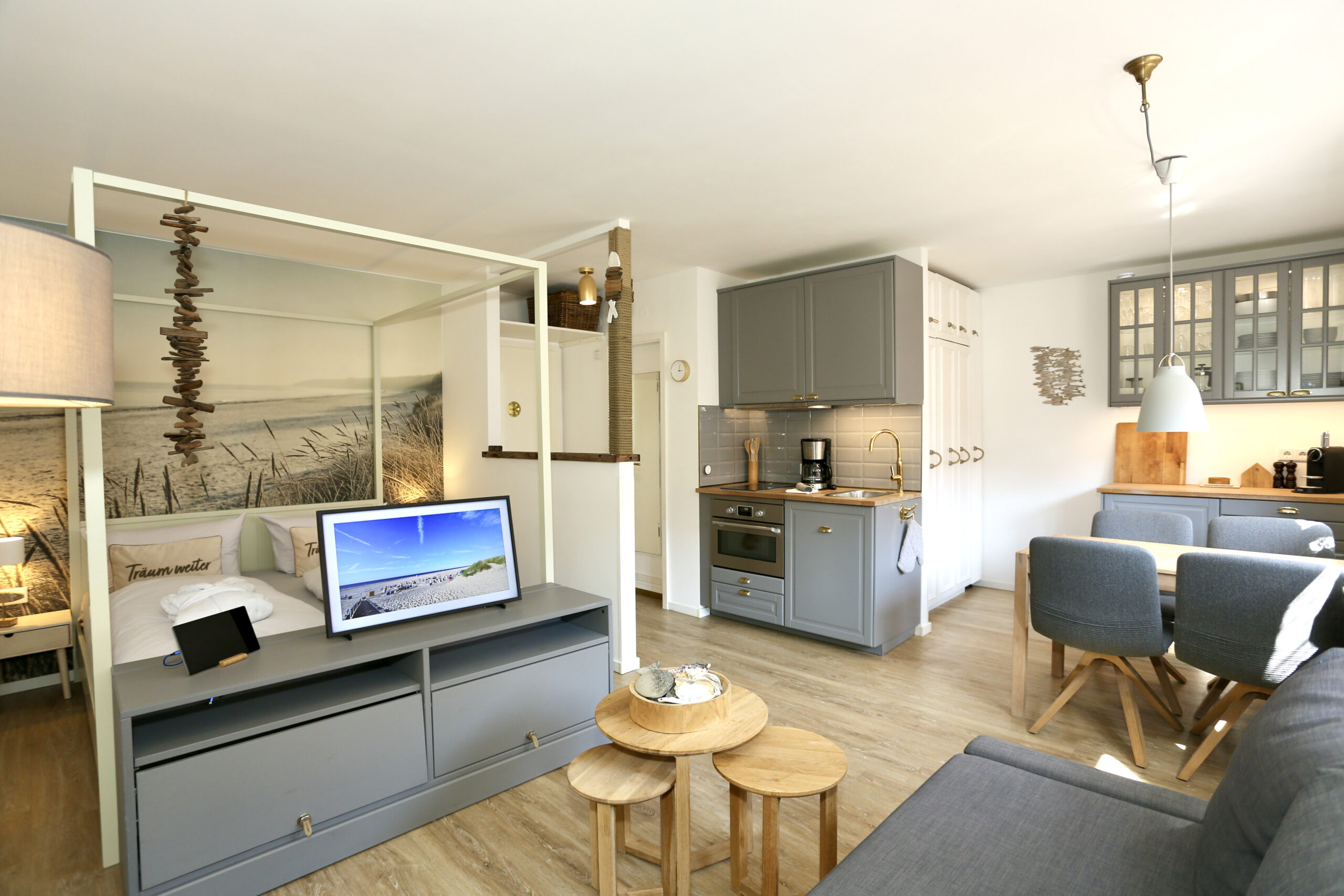 FP7A9019 Wohnbereich mit Couch, Esstisch und moderner Küchenzeile – Deine Juist Ferienwohnung
